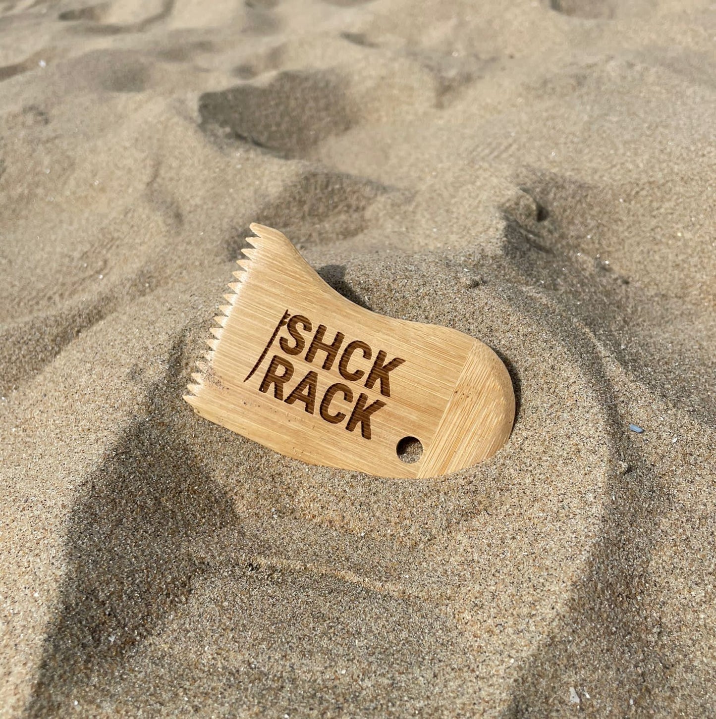SHCK RACK The Comb surfboard wax comb tool in sand